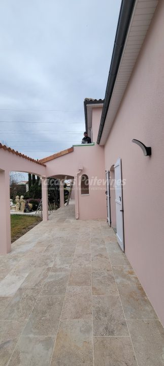 Terrasse carrelée et façade enduite rose rénovée par Façades Poitevines